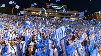 Carolina graduates throw their caps in the air at Spring Commencement in May 2024.